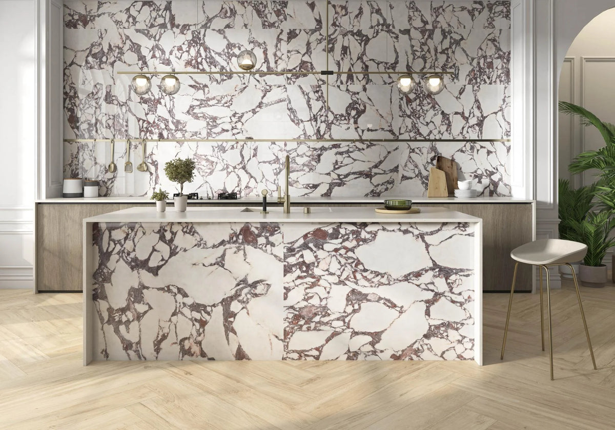 Carrelage Lux Viola effet marbre blanc aux veines pourpres sur une crédence et un îlot de cuisine